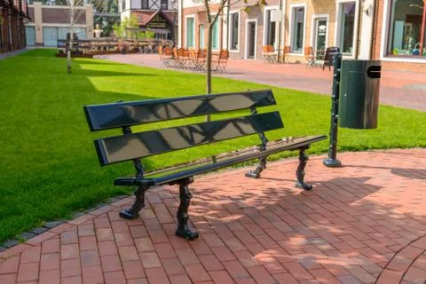 Empty bench and trash can on a city street. 스톡 사진