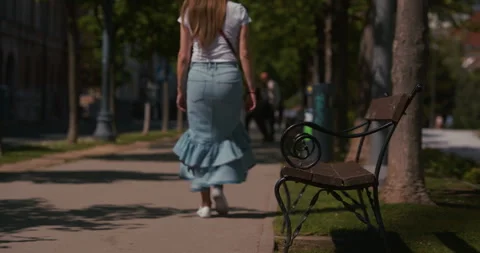 Empty bench beside pedestrian walkway in city park Vídeo Stock 334490732