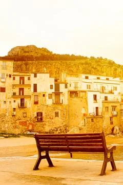 Empty bench captured on a vertical picture in bright orange sunset light. Taken Stock Photos