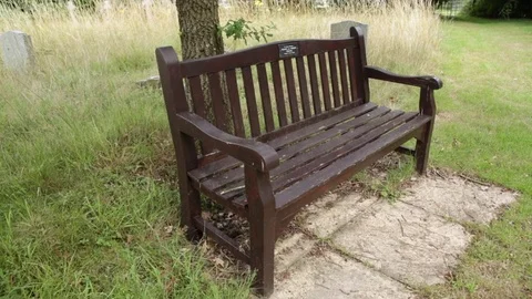 Empty bench at a cemetery - pan Stock Footage 79655336