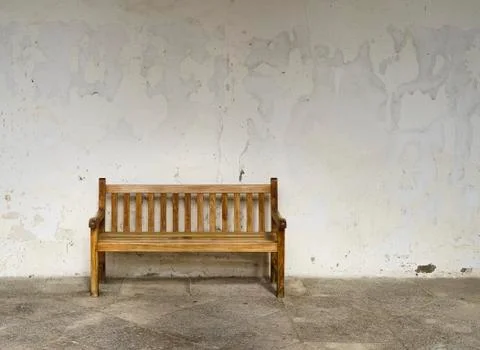 Empty bench with an empty wall in the background Stock Photos