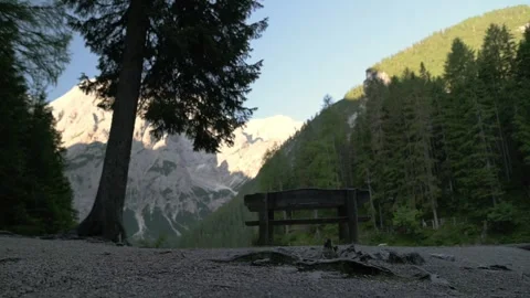 Empty bench facing Lago di Braies with Dolomite mountains in background, Italy Video stock 318259636