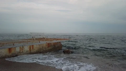 Empty bench on the old breakwater and the flying bird Stock Footage 108785901