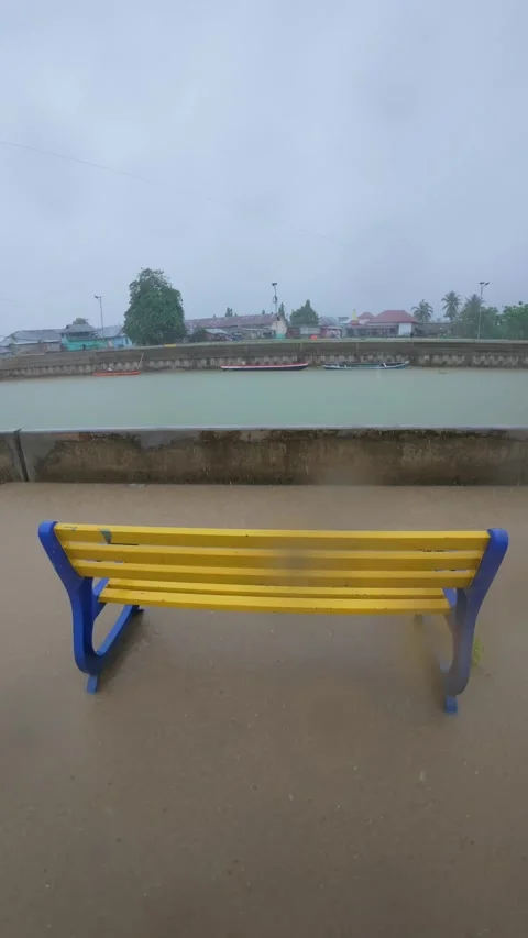 Empty Bench Overlooking River on a Rainy Day Video stock 308499415