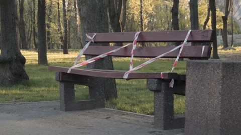 Empty bench with restrictive tape at the park Stock Footage 129240247