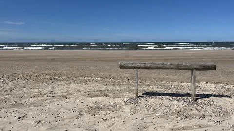Empty bench on a sandy beach overlooking the Baltic Sea. Copy space Foto stock