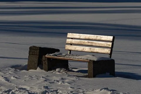 Empty bench in snowy winter park Stock Photos
