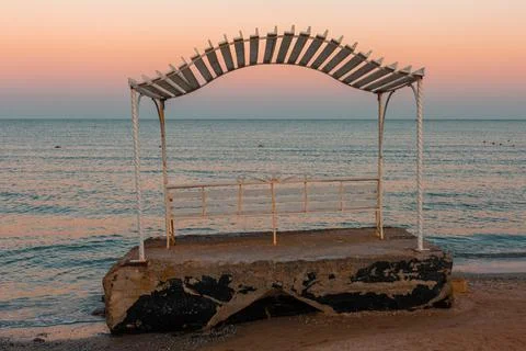 Empty bench on a veranda overlooking the sea on a sunset Stock Photos