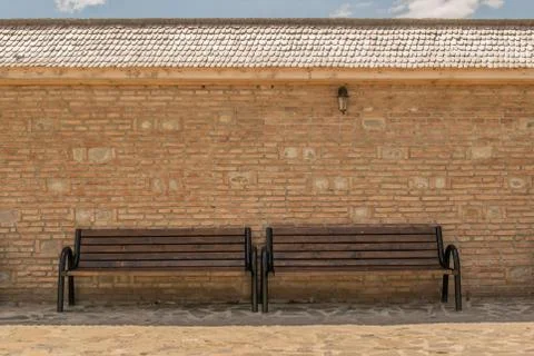 Empty benches with brick wall background, wood tiles roof and vintage wall li Stock Photos