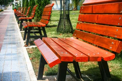 Empty benches in row by the sidewalk Stock Photos