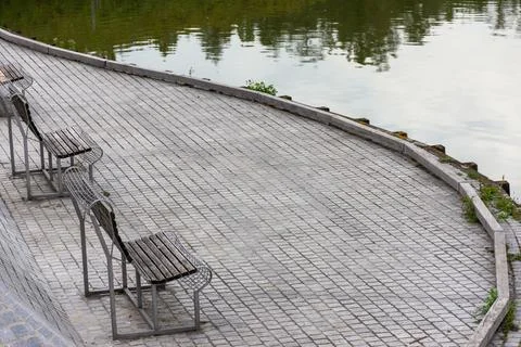 Empty benches on the shore of a large lake Stock Photos
