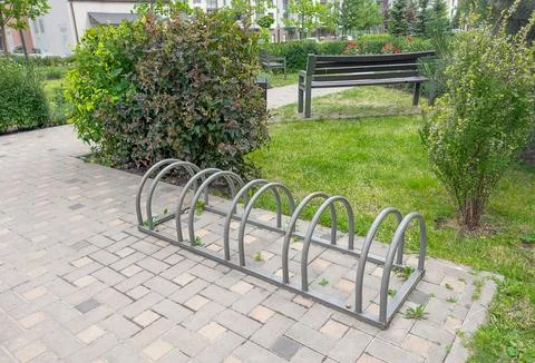 Empty bicycle parking rack beside green landscaped garden in modern residen.. Stock-Fotos