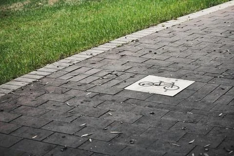 An empty bicycle path in a public park between grass verges Stock Photos