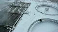 Empty big round tanks for waste water treatment in factory. Snow-covered area HD Footage