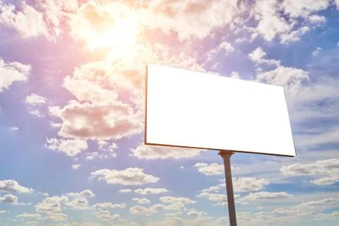 Empty billboard on a background of cloudy sky and bright sun Stock Photos