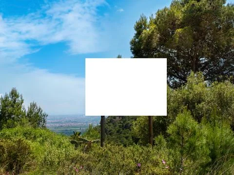 Empty billboard on a hill with tree on a background under blue sky Stock Photos