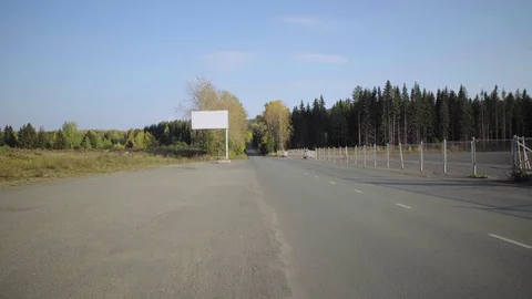 An empty billboard next to a road in the suburbs. Video stock 129772307