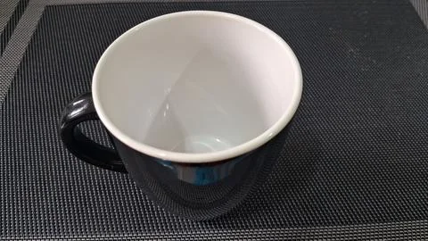 Empty black and white ceramic coffee mug on textured surface Stock Photos