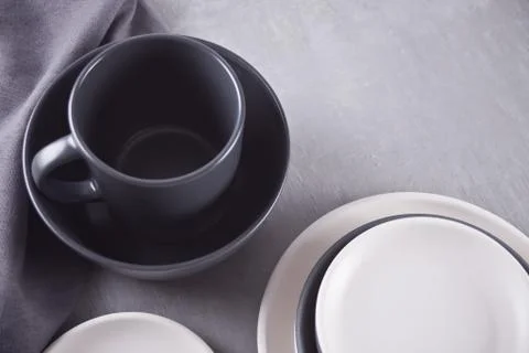 Empty black and white plates over gray table. Stock Photos