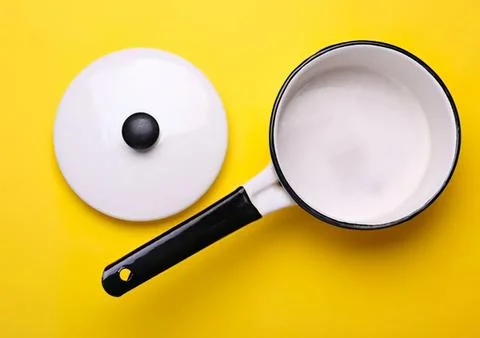 Empty black and white pot with lid on yellow background Foto stock