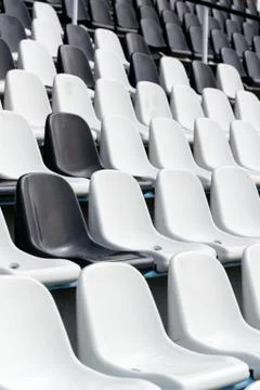 Empty black and white stadium seats mixed in rows, diversity concept 库存照片