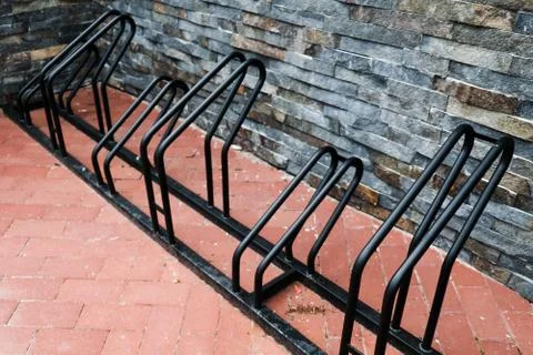 Empty black bicycle rack during pandemic. No people out on parking Stock Photos