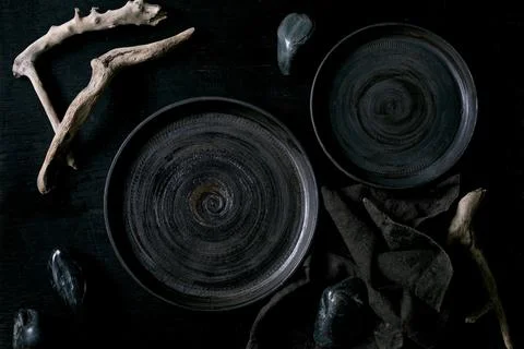 Empty black ceramic plates with black stones Foto stock