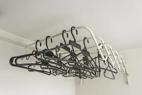 Empty Black clothing hook over a white clothes line. indoor concept Stock Photos