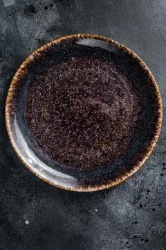 Empty black craft plate on table. Table setting. Black background. Top view.. Stock Photos