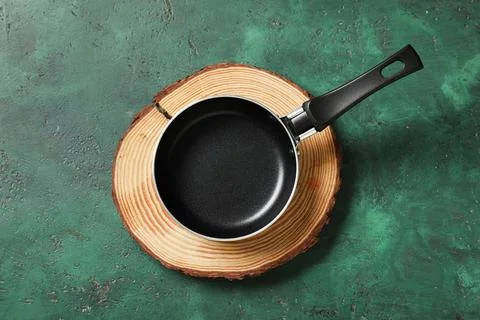 Empty black frying pan on rustic wooden slice, kitchen utensil for cooking an Stock Photos