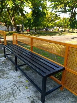 An empty black-orange park bench in the morning Stock Photos