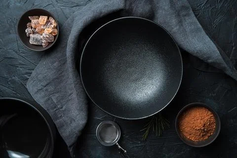 An empty black plate on a black background. Top view. Foto stock