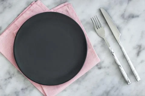 Empty black plate on dark stone background. Stock Photos
