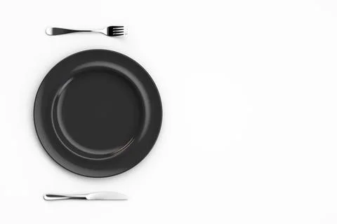 Empty black plate with fork and knife on a white table. View from above. Copy Stock Photos