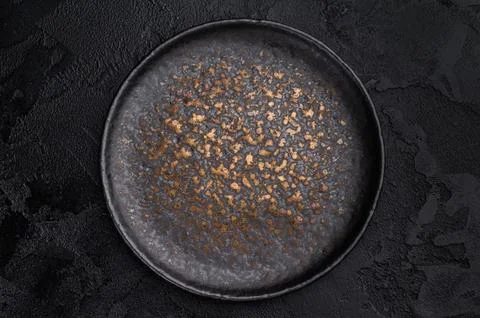 Empty black plate top view on dark textured background. Minimal luxury tabl.. Stock Photos