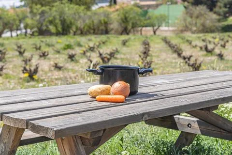 Empty black pot and vegetable on the gray wooden table outdoor Stock Photos