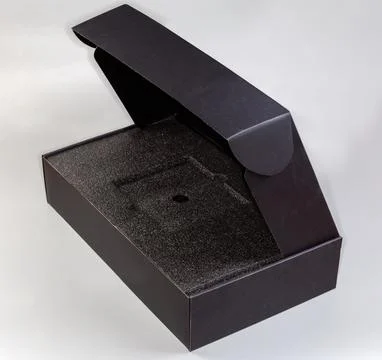 Empty black rectangular cardboard box with partly open lid Stock Photos