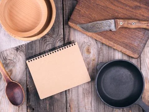 Empty black round frying pan with handle and spoon Stock Photos