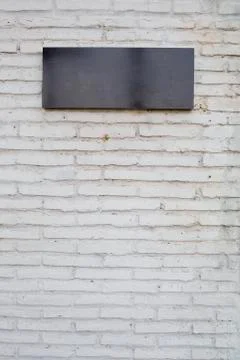 Empty black sign made from marble board on white brick wall Stock Photos