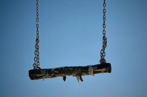 Empty black swing in a blue sky Stock Photos