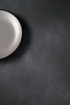 Empty blank gray ceramic round plate or dish on black stone background with c Stock Photos