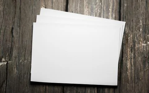 Empty blank horicontal sheets isolated on dark wood background to replace your Stock Illustration