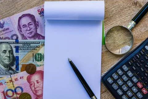 Empty blank notebook with colorful international banknotes and calculator. Stock Photos
