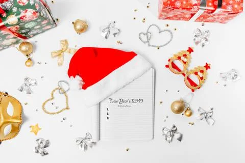 Empty blank notepad with santa hat. Christmas golden ornaments on a white bac Stock Photos