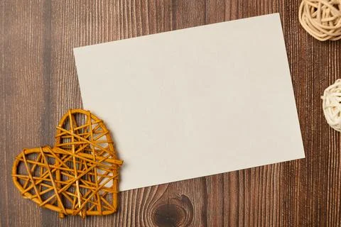 Empty blank paper sheet with heart on wooden background from above. Space for Stock Photos