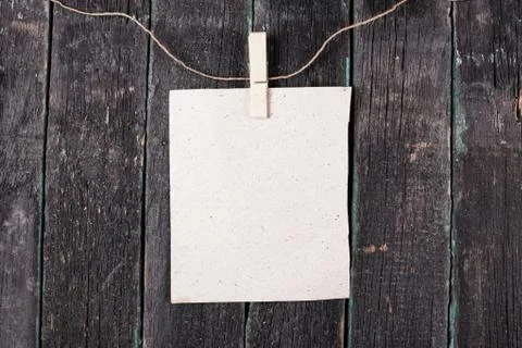 Empty blank on rope with clothespin, old wooden background Foto stock