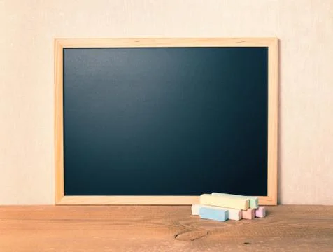 Empty blank school black board with colorful chalks on wooden background, clo 스톡 사진