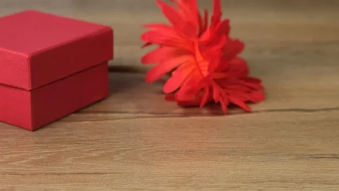 Empty blank visiting card with red flowers and gift box. Close up. Vidéo 125337743