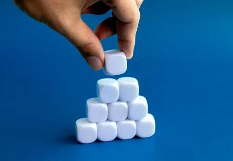 Empty blank white dice block in hand put on cube blocks stack pyramid shape.. Stock Photos