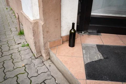 Empty blank wine bottle on a building entrance step Stock Photos